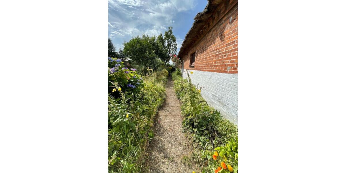 Seitlicher Gartenweg entlang der Backsteinfassade