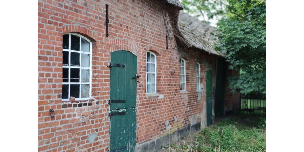 Backsteinfassade mit historischen Fenstern und Seiteneingang